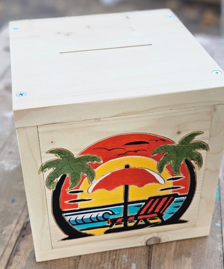 One of Keno's pine piggy banks, an island sunset carved and painted on the front